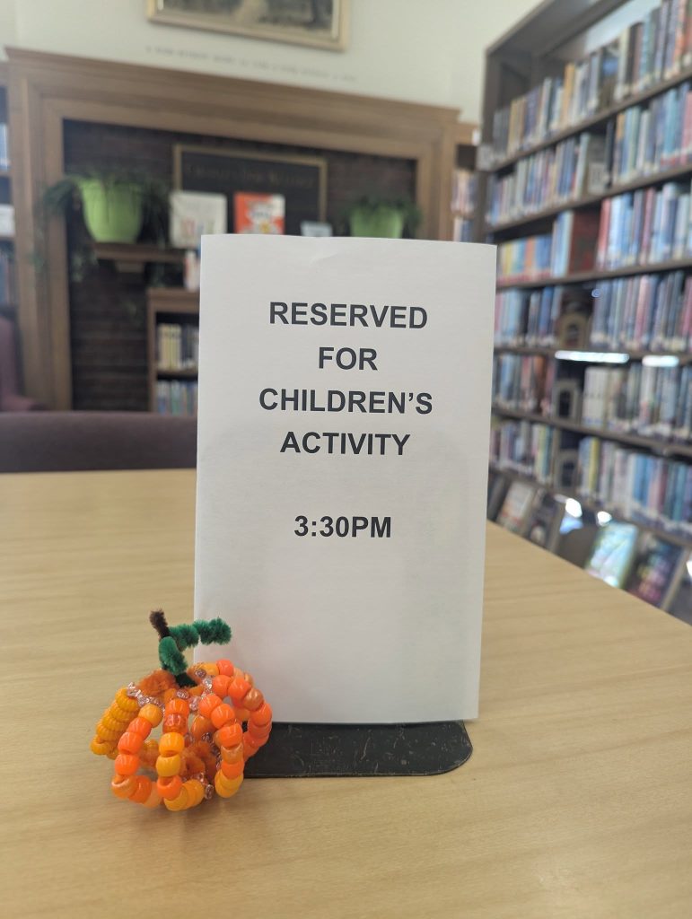 Photo of sign on table stating, "RESERVED FOR CHILDREN'S ACTIVITY 3:30PM."