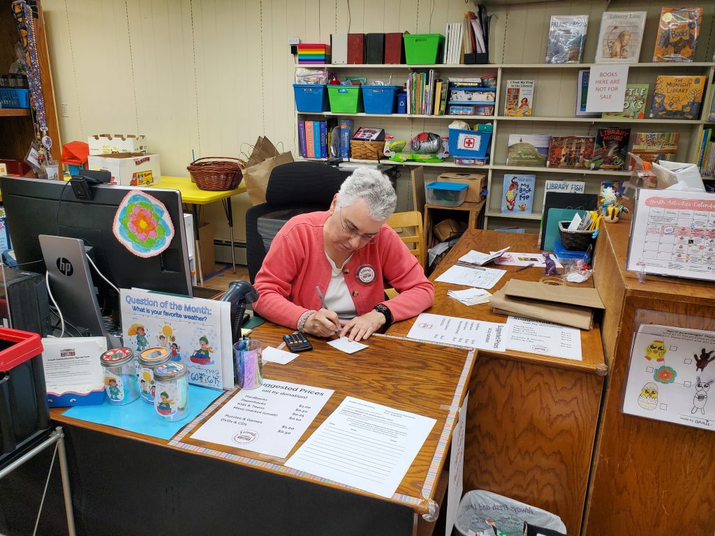 Photograph of a volunteer at a library desk